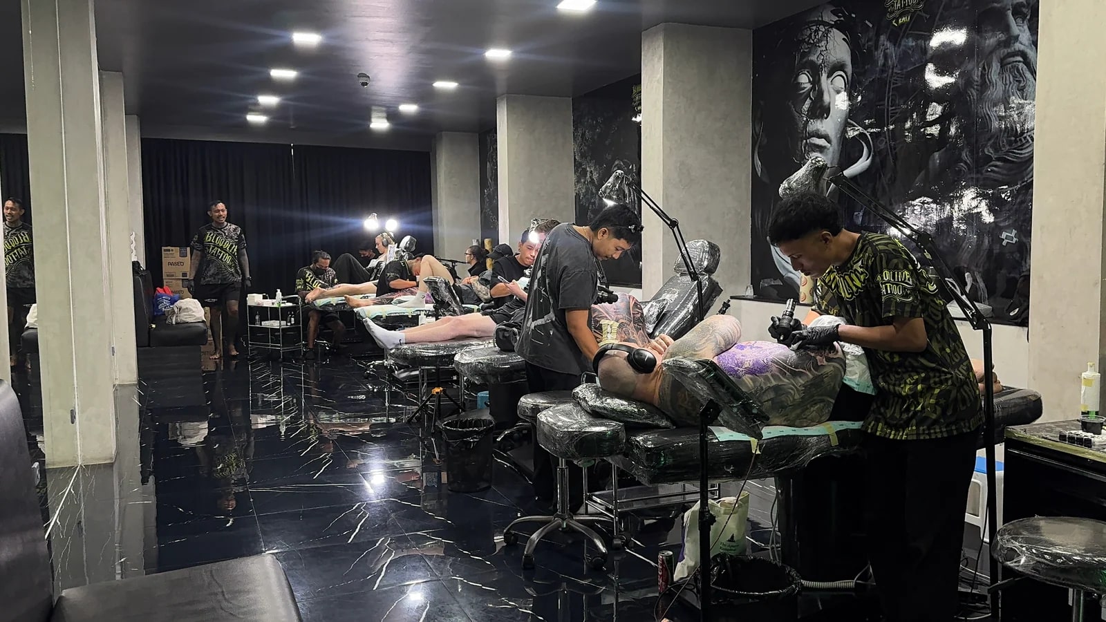 Bali tattoo artist at work in professional studio with multiple stations