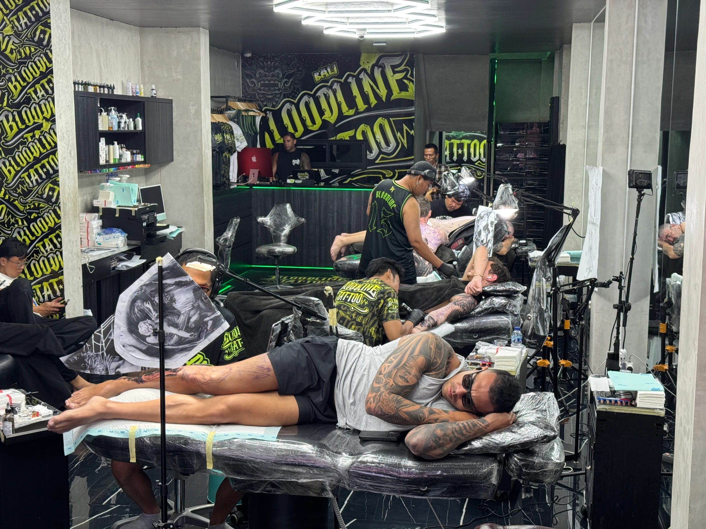 Bloodline Tattoo Bali studio floor with artists working under sterile conditions and branded Bali wall mural