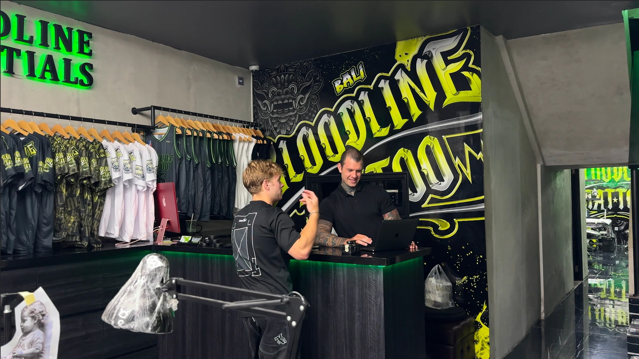 Client discussing tattoo pricing and booking at the Bloodline Tattoo Bali reception desk