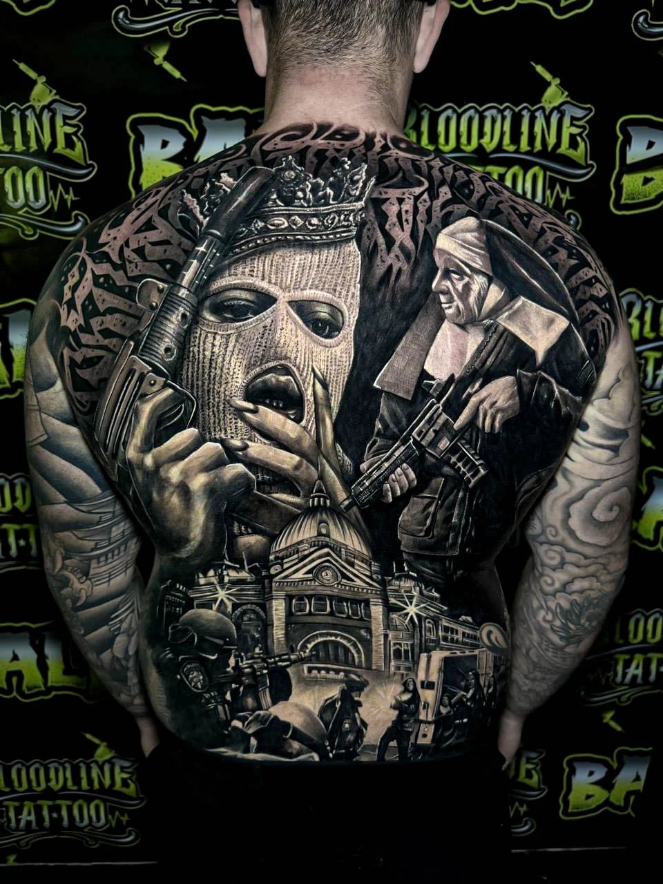 Detailed black and grey Chicano full back tattoo featuring a crowned ski mask woman, armed nun, cathedral facade, and riot scene at Bloodline Tattoo Bali.