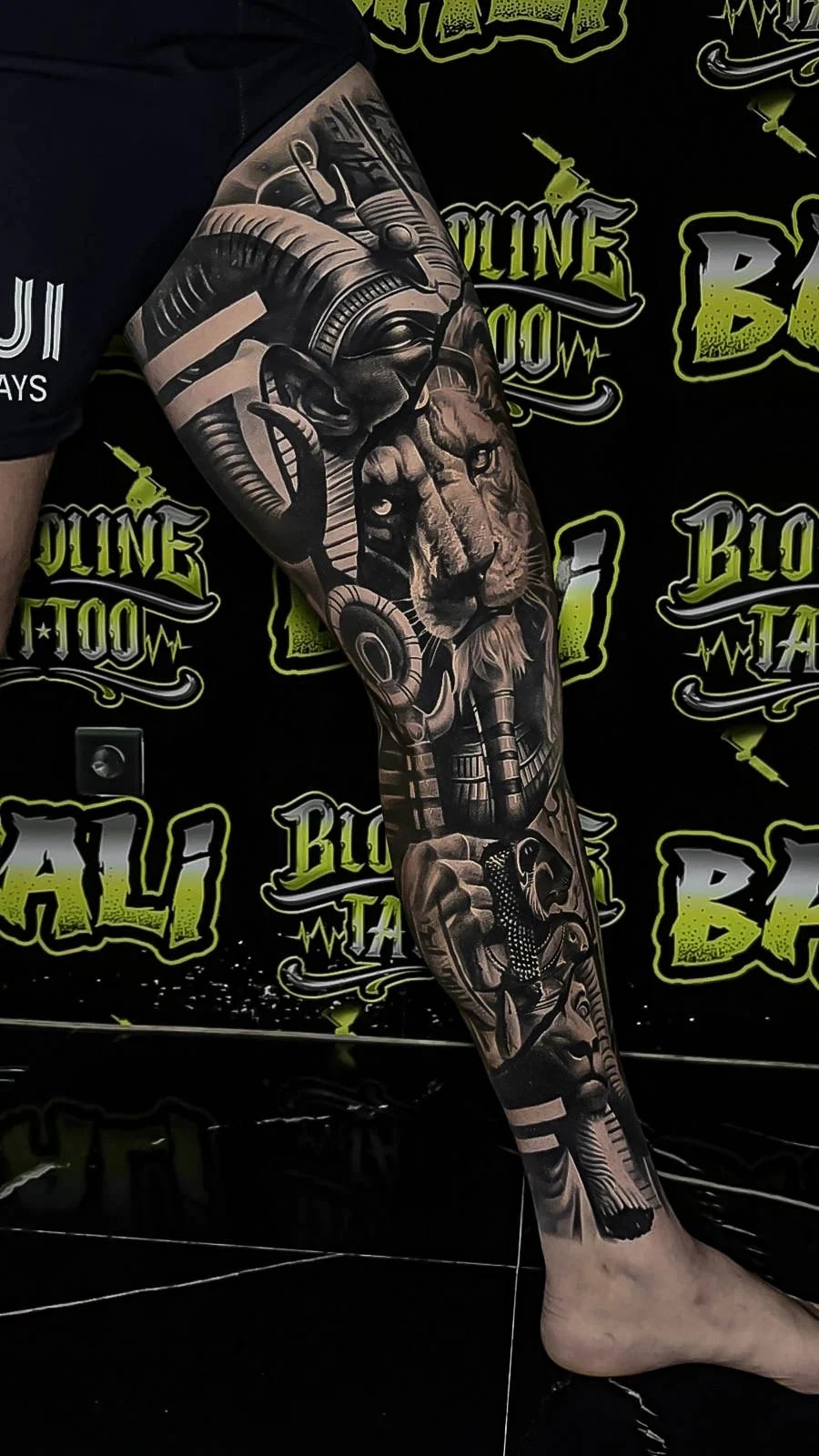 Healed surreal leg sleeve with a mechanical ram, lion portrait, and robotic hand motif, holding rich blacks and clean healed contrast at Bloodline Tattoo Bali.