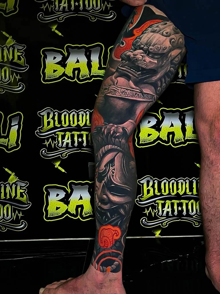 Healed Japanese sleeve with temple guardian faces, mask imagery, and orange cloud accents, showing durable color saturation and healed edge clarity at Bloodline Tattoo Bali.