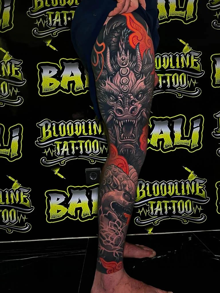 Healed Japanese leg sleeve with a snarling dragon and orange cloud accents, showing strong healed saturation and crisp line separation at Bloodline Tattoo Bali.