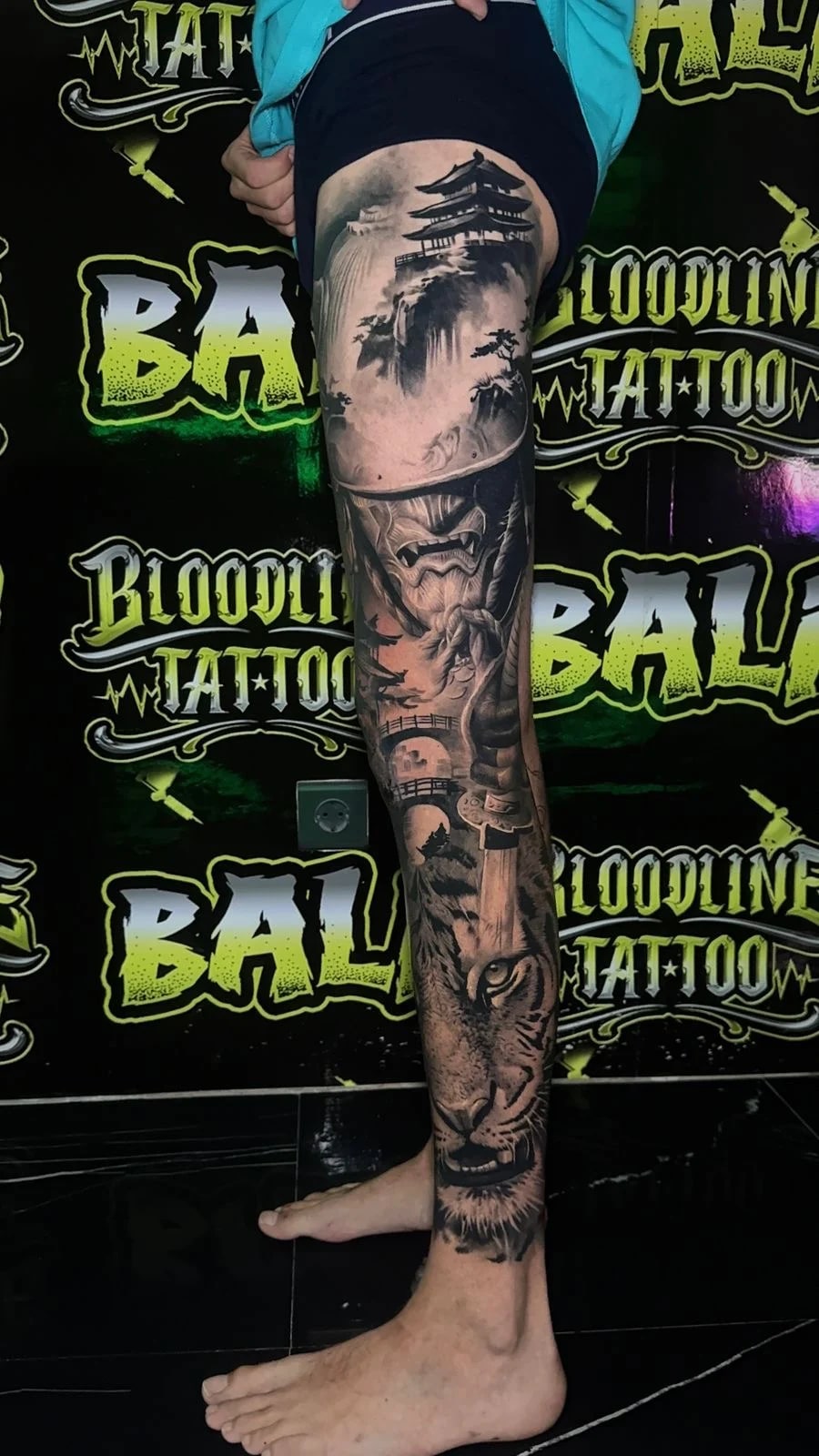 Healed leg sleeve with a pagoda scene, Hannya mask, and tiger portrait, showing soft greywash depth and crisp healed detail at Bloodline Tattoo Bali.