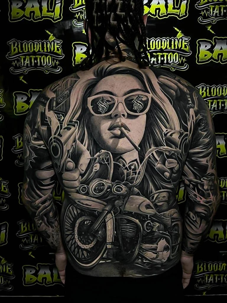 Healed outlaw backpiece with a smoking woman, motorcycles, guns, and black-and-grey realism that keeps strong contrast and clean detail at Bloodline Tattoo Bali.