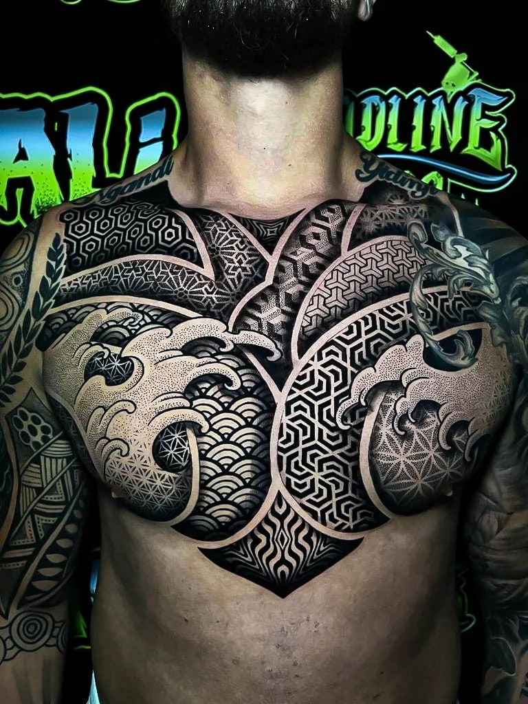 Geometric chest panel with Japanese wave fill, sacred-geometry fields, and heavy blackwork contrast shaped cleanly across the pecs at Bloodline Tattoo Bali.