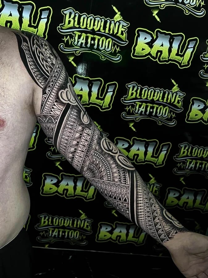 Polynesian-style forearm section with interwoven tribal bands, fine triangle texture, and clean blackwork rhythm wrapping the arm at Bloodline Tattoo Bali.
