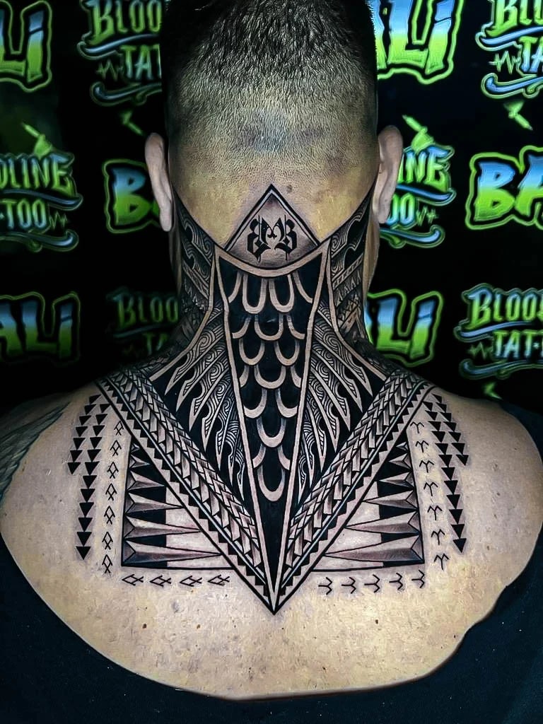 Symmetrical neck and upper-back tribal blackwork with spearhead geometry, chevron bands, and high-contrast negative space at Bloodline Tattoo Bali.