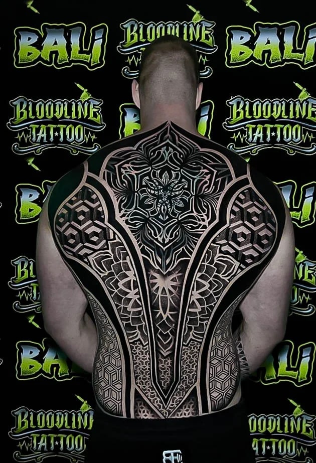 Full-back sacred geometry suit with cube tessellation, lotus-based symmetry, and layered blackwork panels running shoulder to waist at Bloodline Tattoo Bali.