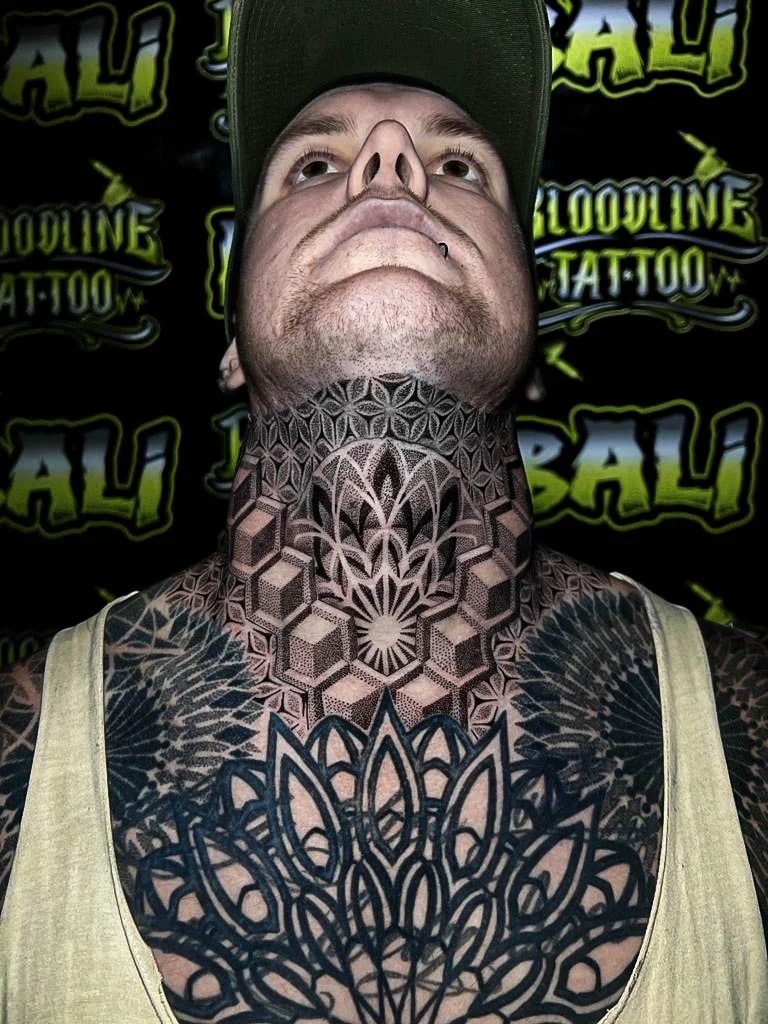 Geometric throat tattoo with a central rosette, Flower of Life texture, and 3D cube borders locking into the neck and upper chest at Bloodline Tattoo Bali.
