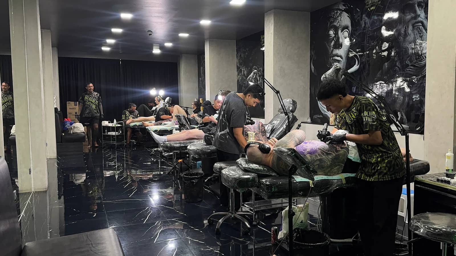 Bali tattoo artist at work in professional studio with multiple stations