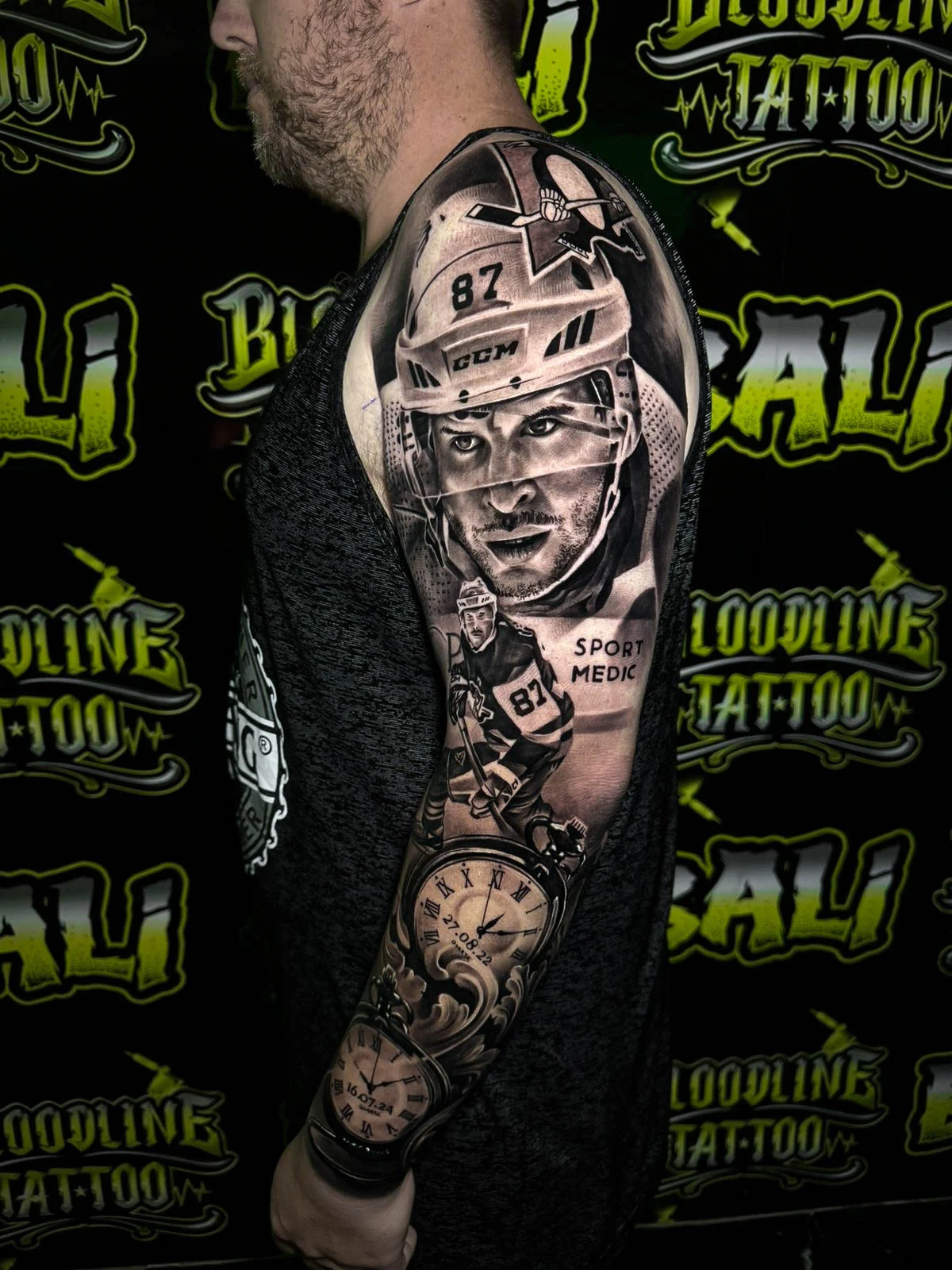 Black and grey portrait realism arm sleeve tattoo of a number 87 ice hockey player with action pose and memorial clock elements at Bloodline Tattoo Bali.